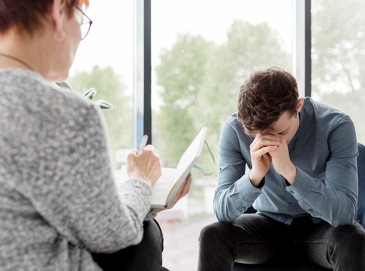 A diverse group of university students engaged in an open discussion about mental health in a supportive campus setting.