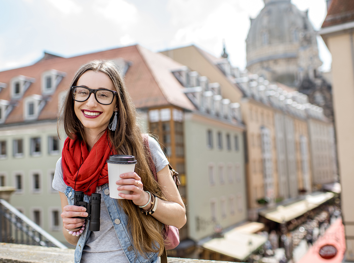 A happy student enjoying coffee inside a university campus, embracing academic life.