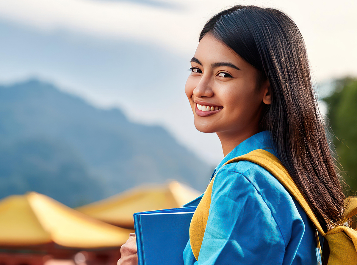 A very happy Asian student inside a university campus, enjoying student life.