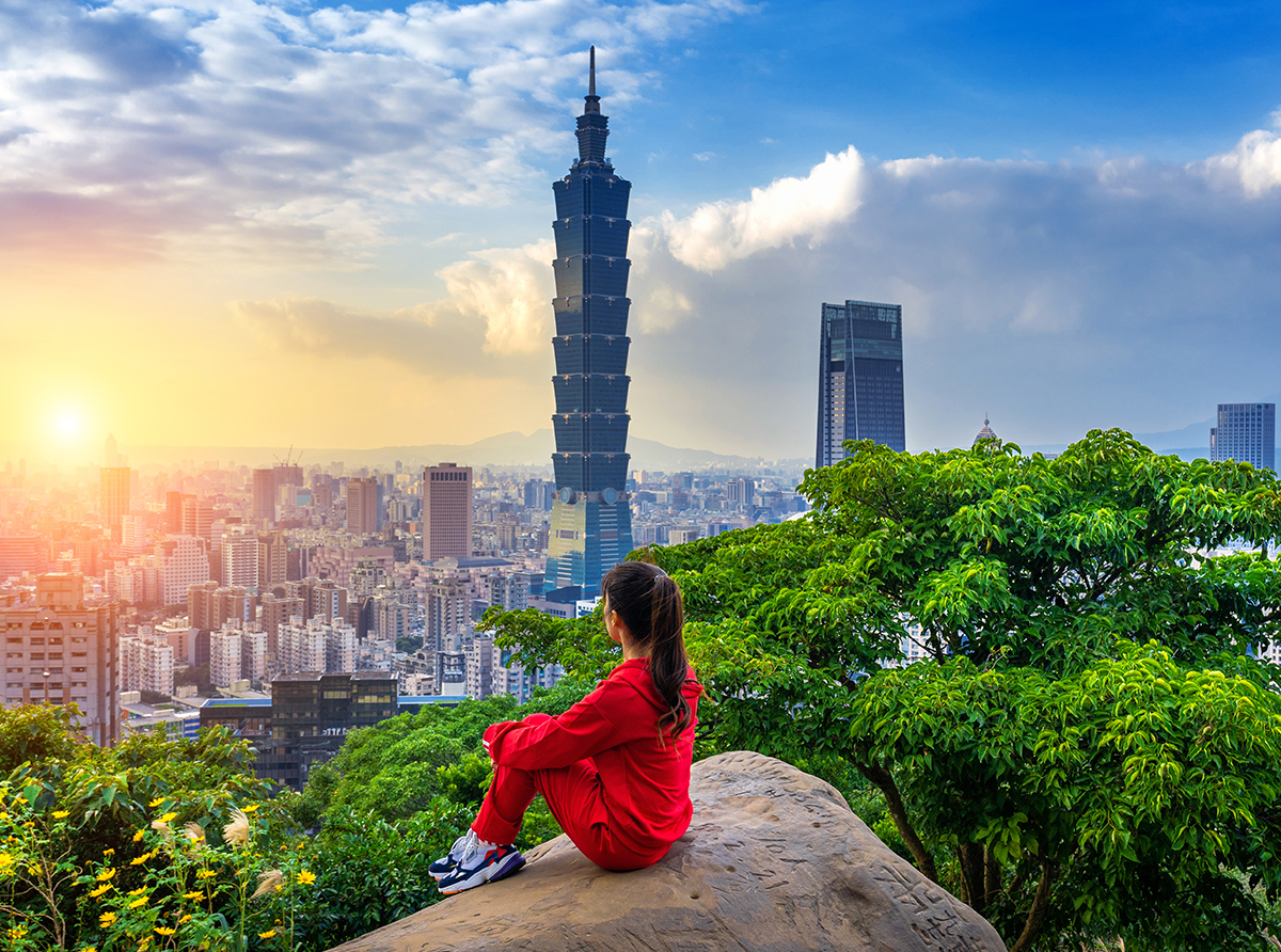 A student sitting on a mountain overlooking the city, inspired by a bright academic future.