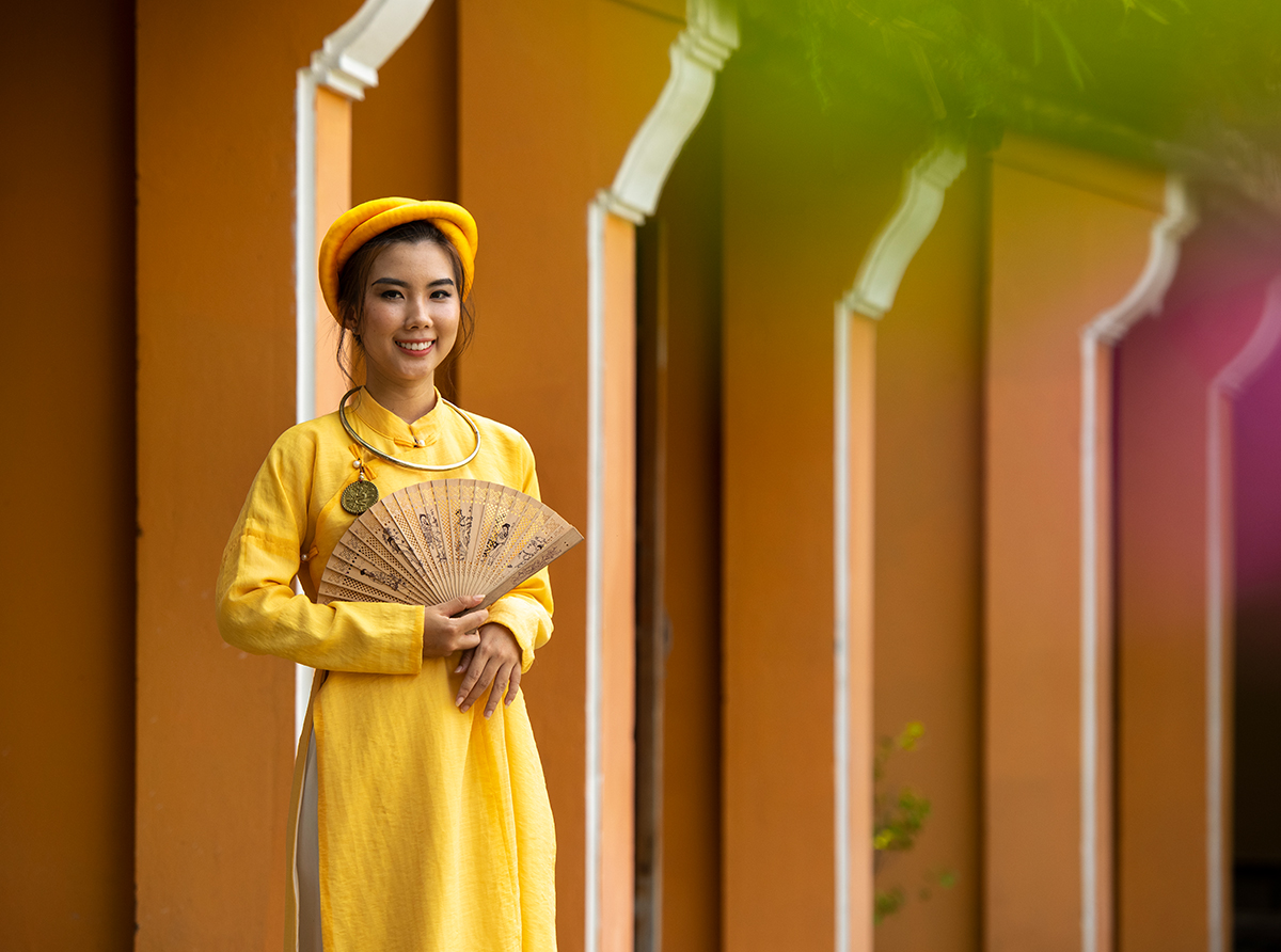 A student wearing traditional clothing inside a university campus, celebrating culture and education.